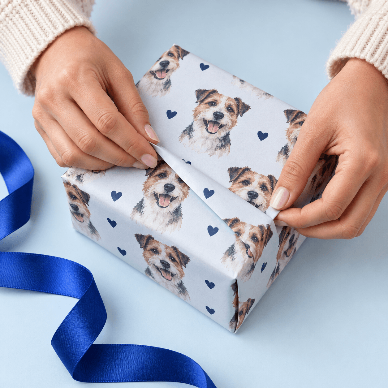 Hands wrapping a gift in patterned paper